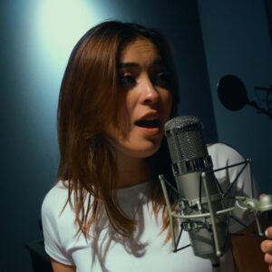 Photo of Leslie Avendano, singing into a microphone